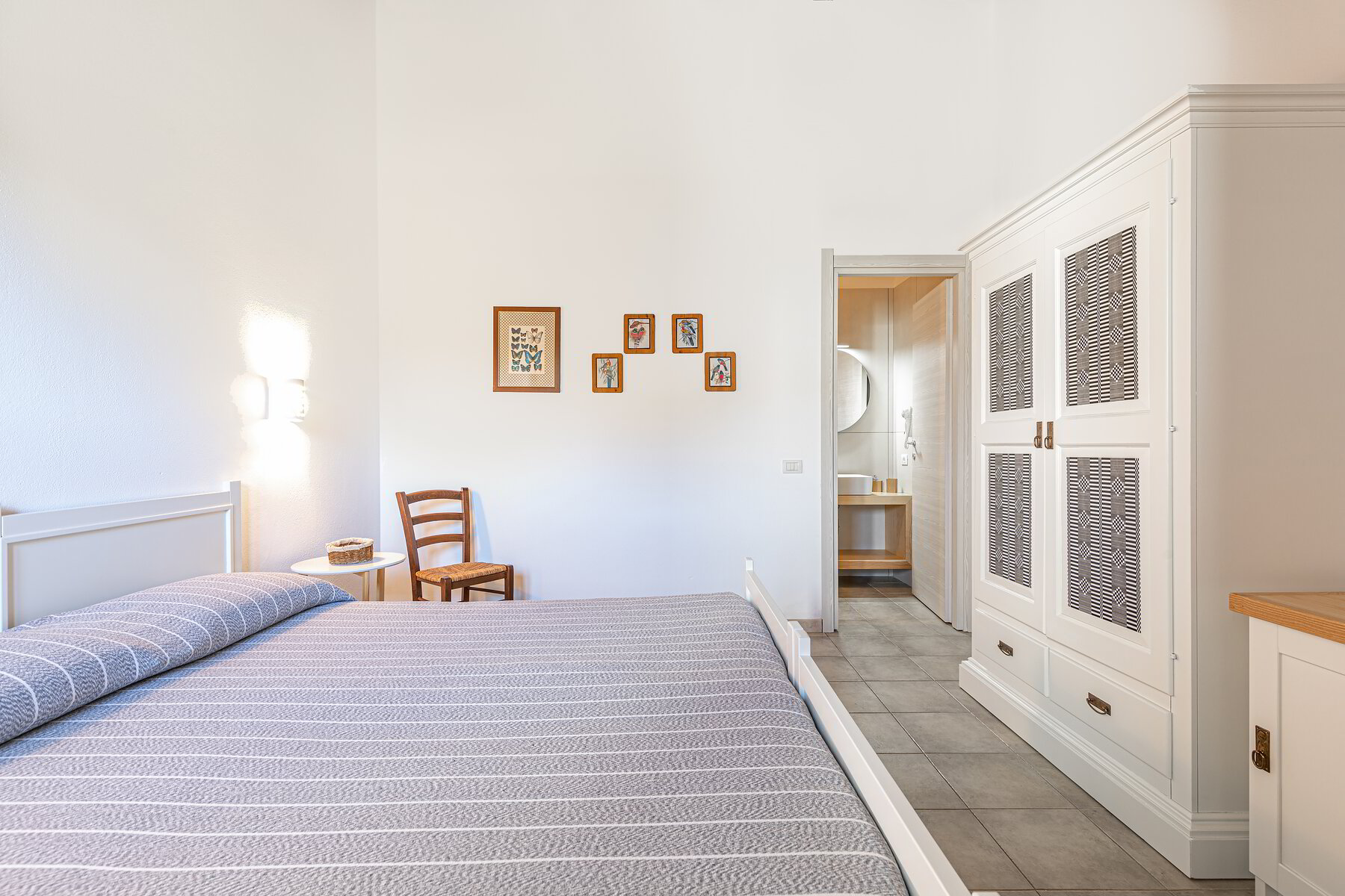 Camera di Casa Marmida con letto matrimoniale e arredi in arte povera